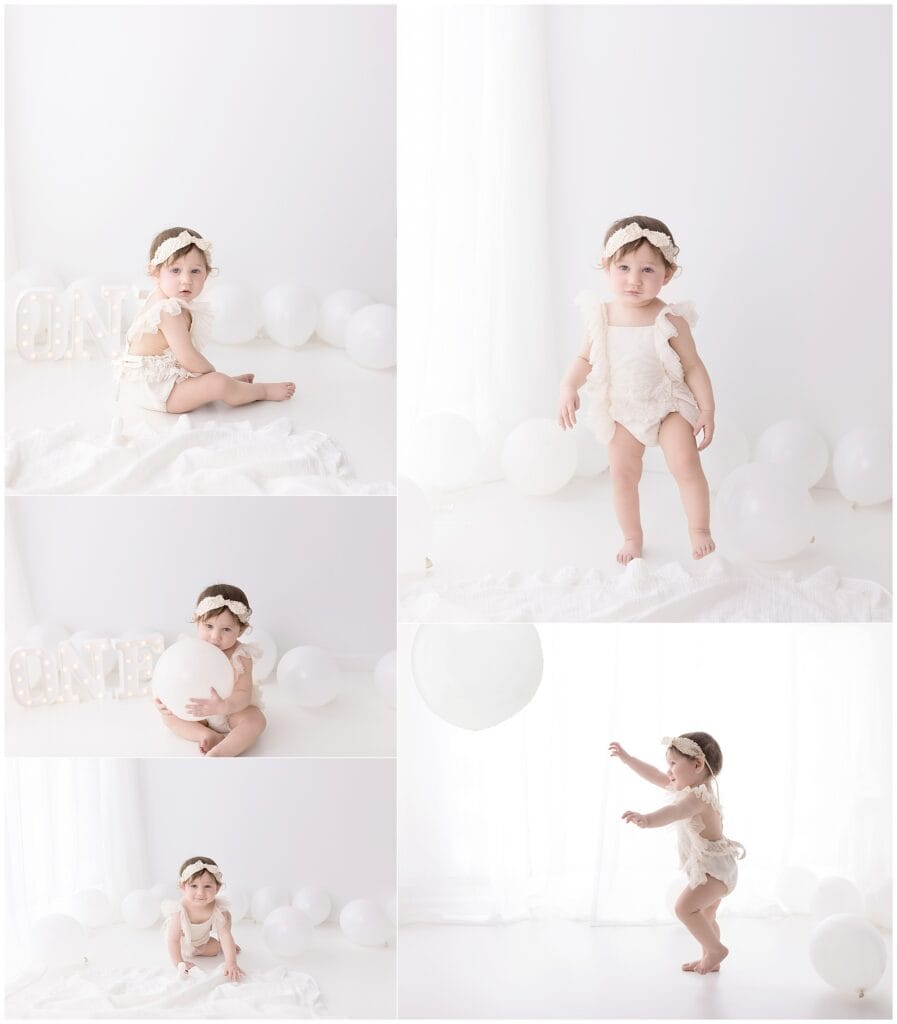 Soft white baby photo shoot with balloons and natural lighting, capturing adorable infant moments in a minimalist studio setting.