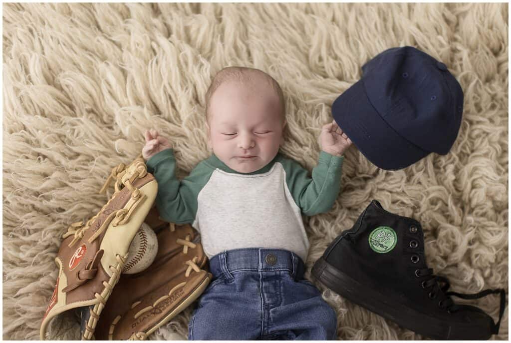 Adorable baby Benny with tiny baseball glove honoring Sandlot movie name inspiration newborn photographer Brunswick Ohio