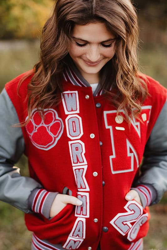 What to Wear for Senior Pictures Senior photos of athletic student with varsity jacket