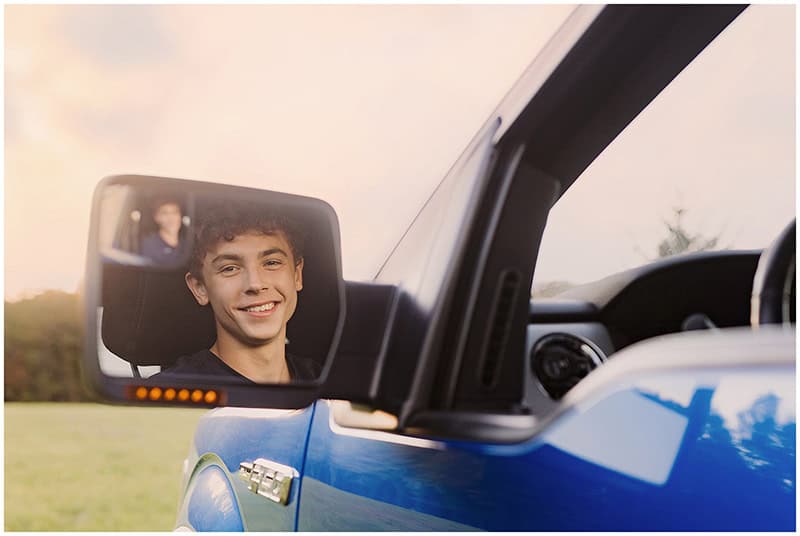 A boy looking in his truck's mirror by Medina Ohio Senior Photographer Mary Christine Photography