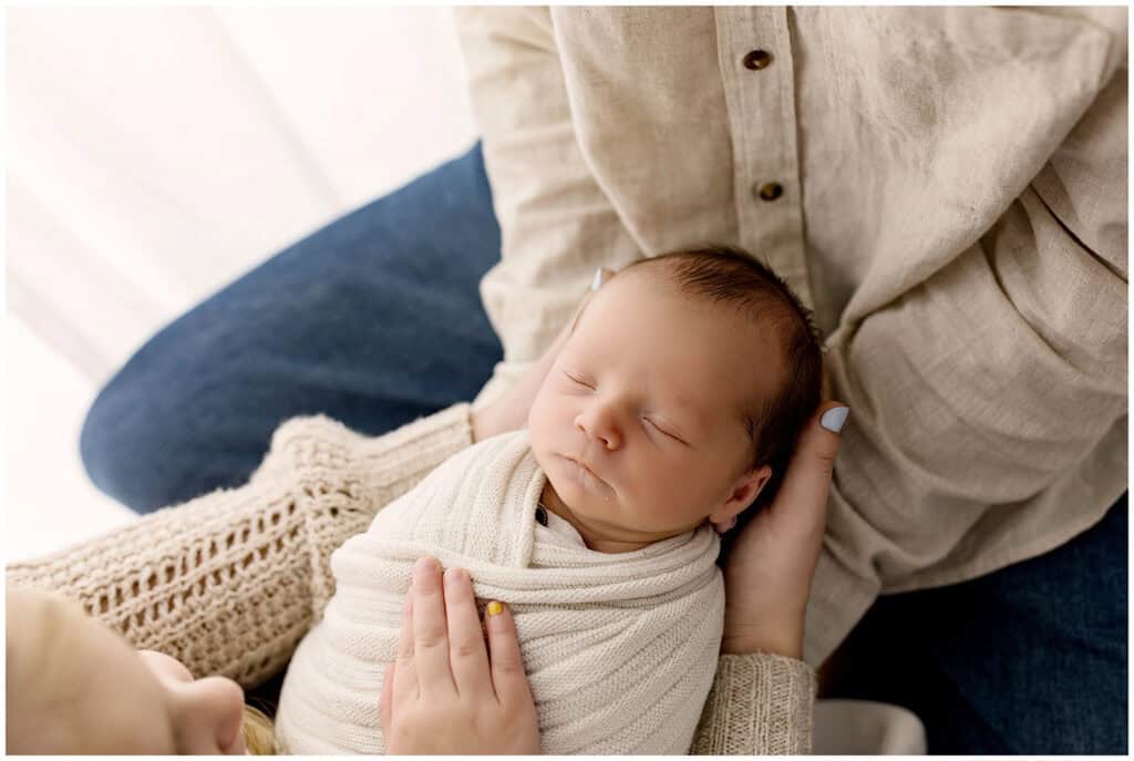 Family with their baby during a Cleveland baby photographer session with airy, timeless styling.