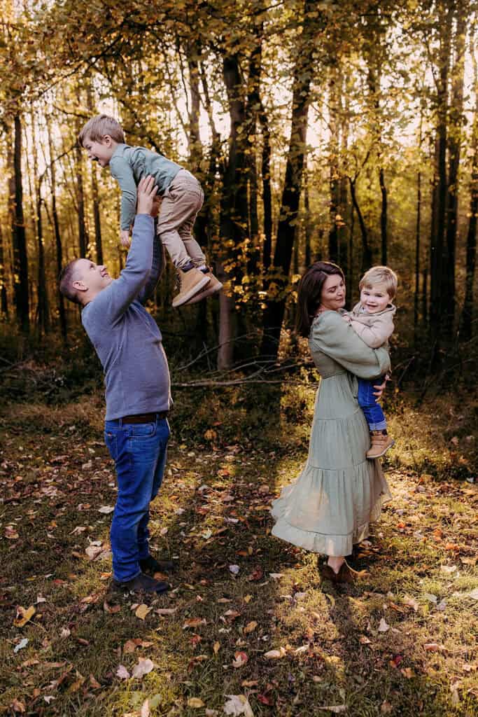 Parents playing with children surrounded by golden leaves
