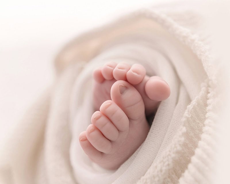 Tiny newborn toes photographed softly during the best age for newborn photos.