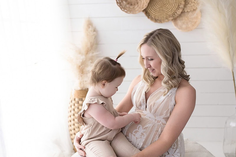 A pregnant mom sharing a quiet moment with her toddler during a sibling-inclusive maternity session.