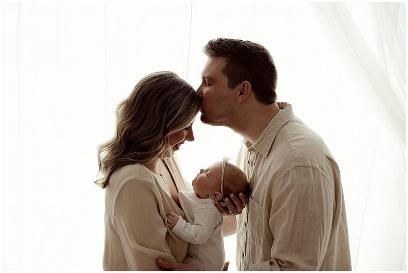lifestyle newborn photo of mom holding baby in natural window light