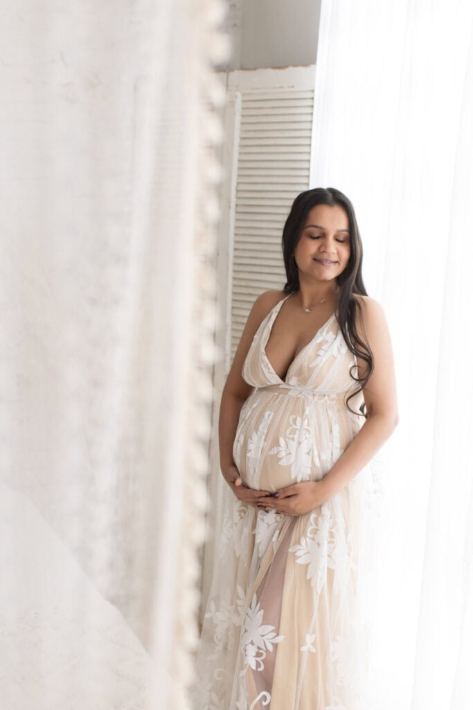 Expecting mom in a flowing dress with soft natural makeup during a light and airy maternity session near Akron Ohio