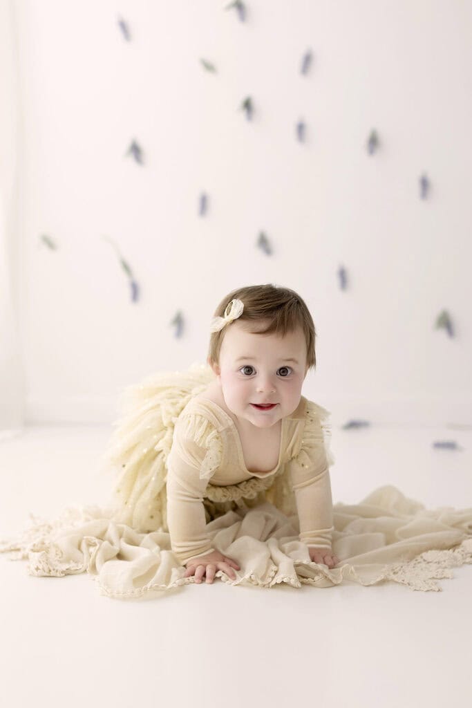 Baby girl crawling during a milestone photo session capturing this developmental stage