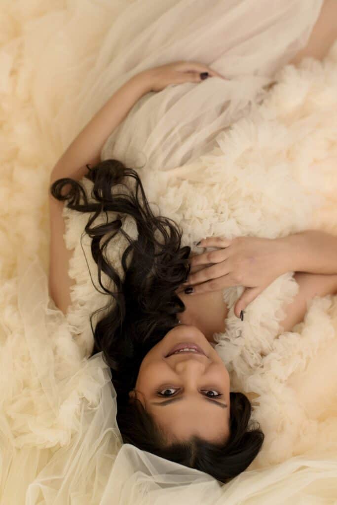 Close up maternity portrait with soft glam hair and makeup in a neutral toned Cleveland photography studio