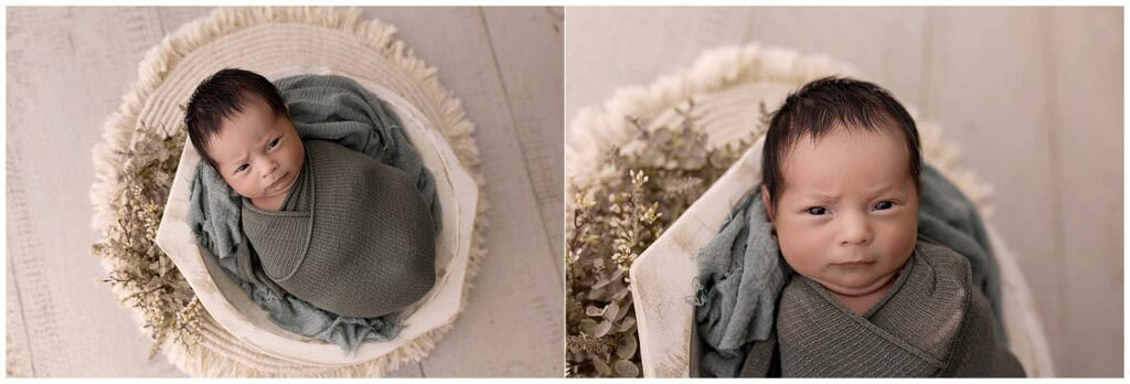 Awake newborn baby boy wrapped in green swaddle during newborn session